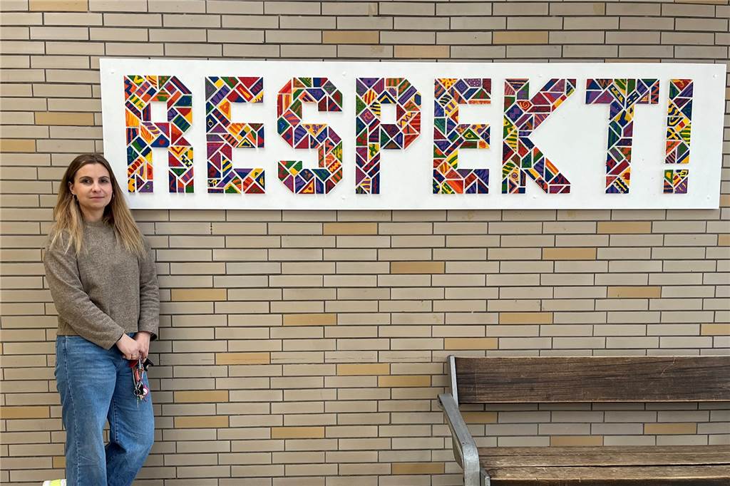 Lehrkräftemangel: Lena Tesch ist Seiteneinsteigerin an der JHS Lena Tesch steht vor einem Plakat. Darauf steht "Respekt!".
