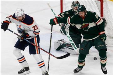 Leon Draisaitl von den Edmonton Oilers (l) verfehlt den Pass, neben Jonas Brodin und Goalie Devan Dubnyk von Minnesota Wild. Foto: Jim Mone/AP