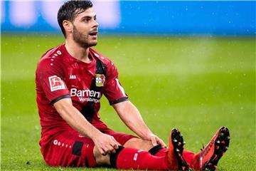 Leverkusens Kevin Volland sitzt auf dem Rasen. Foto: Marius Becker/Archiv