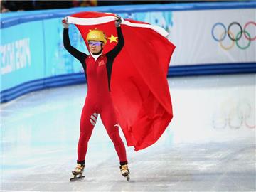 Li Jianrou feiert auf einer Ehrenrunde mit der Fahne Chinas ihren Olympiasieg. Foto: How Hwee Young