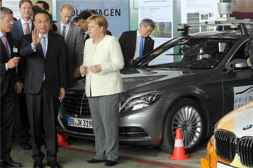 Deutschland und China kooperieren bei autonomen Autos sein Li Keqiang, Ministerpräsident von China, und Bundeskanzlerin Angela Merkel informieren sich auf dem ehemaligen Flughafen Tempelhof bei einer Präsentation über das autonome Fahren. Foto: Wolfgang Kumm