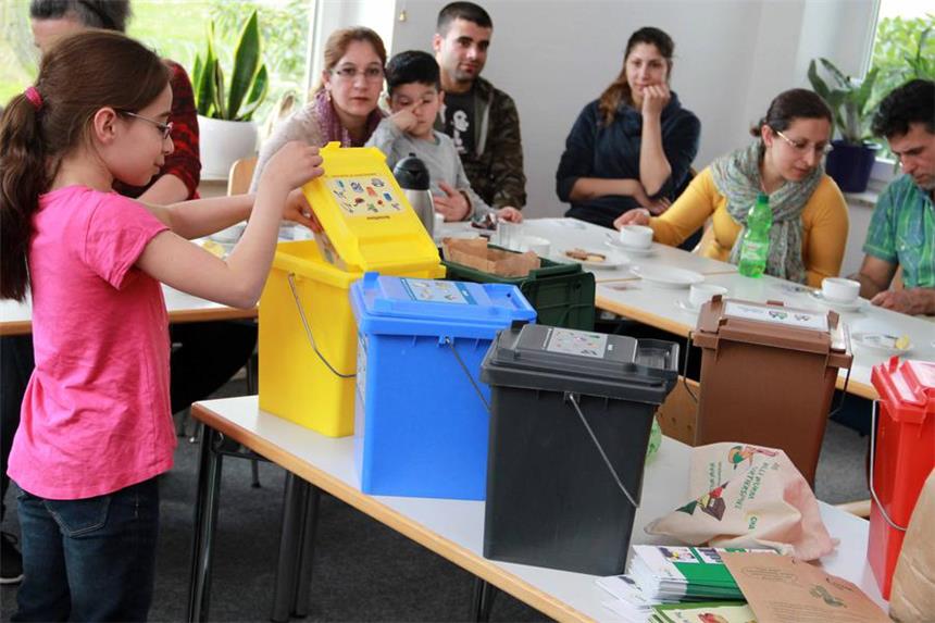 So geht Mülltrennung: Kurs für Flüchtlinge in Selm Lilan ist acht Jahre alt, geht an die Äckernschule in die dritte Klasse und half bei der Verteilung der Müll-Kärtchen in die richtigen Tonnen.