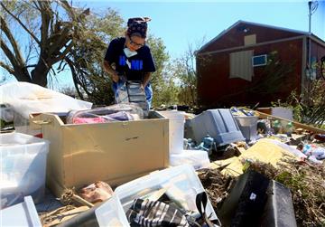 Lillian Gasca sammelt am 29.08.2017 in Bayside (USA) Habseligkeiten aus den Trümmern ihres Hauses, das im Hurrikan Harvey zerstört worden war. Foto: Gabe Hernandez/Corpus Christi Caller-Times/dpa +++(c) dpa - Bildfunk+++