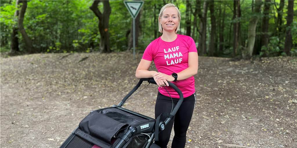 Mit dem Kinderwagen durch den Wald: Lisa Steinke (34) bietet Outdoor-Kurse für junge Mütter an Lisa Steinke mit pinkem T-Shirt und der Aufschrift Lauf Mama Lauf im Wald.