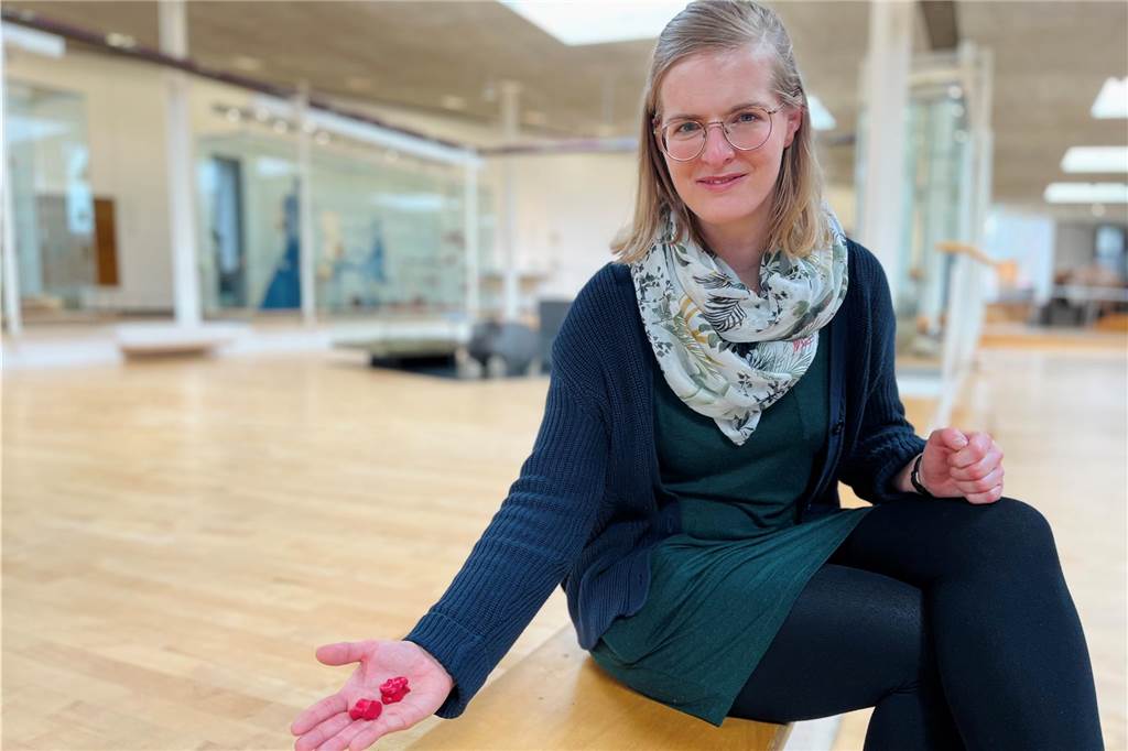 Mit spielerischer App durchs Römermuseum: Neues Angebot für Teenager Lisa Stratmann hält in ihrer offenen Hand zwei Würfel.