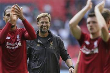 Liverpools Trainer Jurgen Klopp (M) freut sich mit seinen Spielern über den fünften Sieg im fünften Spiel. Foto: Tim Ireland/AP