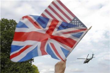London: Während am Himmel der Helikopter Marine One mit US-Präsident Trump an Bord vorüberfliegt, werden unten eine britische und eine us-amerikanische Flagge geschwenkt. Foto: Pablo Martinez Monsivais/AP