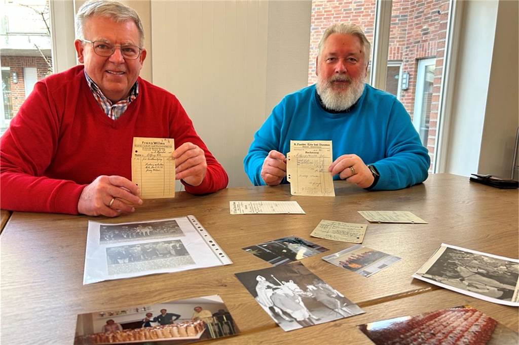 75. Nikolauszug in Erle: Helfer werden dringend benötigt Ludger Askamp und Klaus Elsner sitzen an einem Tisch mit alten Fotos.