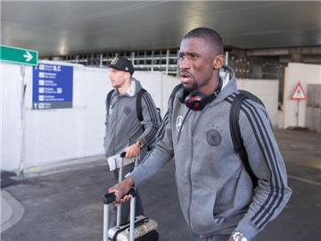 Lukas Podolski (l) und Antonio Rüdiger verlassen nach der Ankunft das Flughafengelände in Frankfurt. Foto: Frank Rumpenhorst