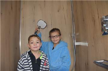 Luke und Laine Kernebeck haben schon mal ausgetestet, wie es ist, im mobilen Bad zu duschen.