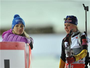Magdalena Neuner (l) gibt Staffelläuferin Miriam Gössner an der Strecke in Ruhpolding hilfreiche Tipps. Foto: Andreas Gebert