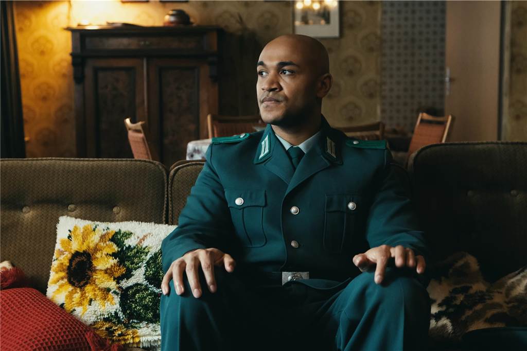 Das Fernsehjahr der starken Frauen: Wer 2024 den Grimme-Preis erhält Eine Szene aus "Sam - ein Sachse": Der afrodeutsche Polizeibeamte Samuel Meffire (Malick Bauer) sitzt in Uniform auf einem Sofa.