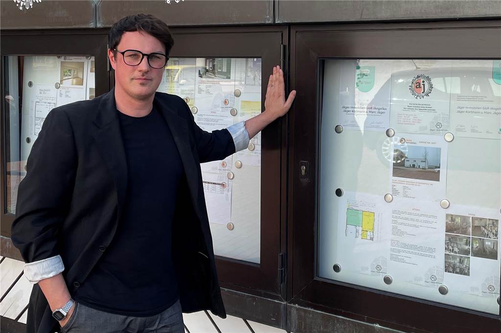 Immobilienpreise in Haltern sinken: Nicht alle Objekte werden günstiger Marc Jäger von Jäger Immobilien steht vor einem Schaukasten.