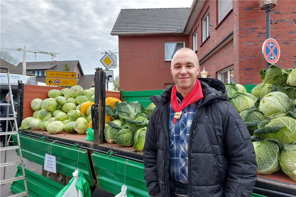 Marc Kuhlmann (r.) aus Büderich steht vor einem Wagen voller Kappes.