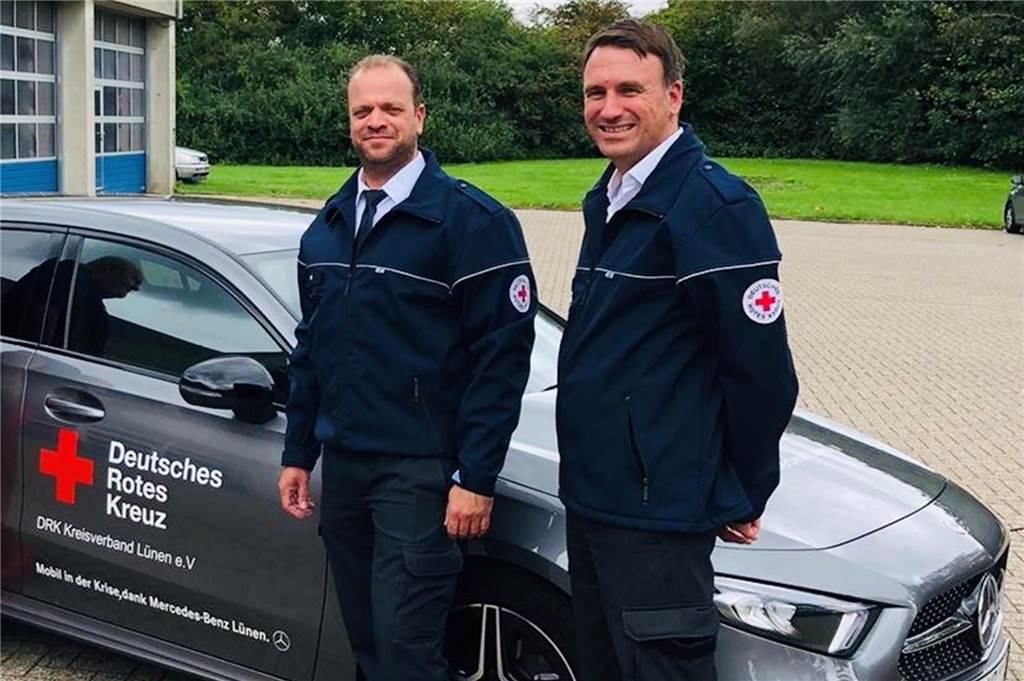 Zwei Männer stehen vor einem Auto.