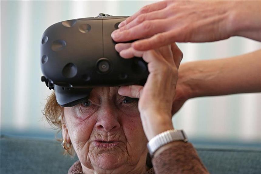 Maria Hertwig bekommt im Caritas-Altenzentrum St. Maternus eine Virtual Realitiy Brille aufgesetzt. Foto: Oliver Berg