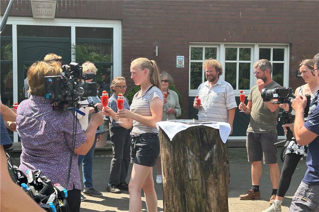 Maria Schulte Spechtel über ihren ersten Auftritt vor der Kamera Maria Schulte Spechtel verteilt Sekt an ihre Gäste auf dem Waldhof Schulte Spechtel in Dorsten. Um sie herum nehmen Kameras alles auf.