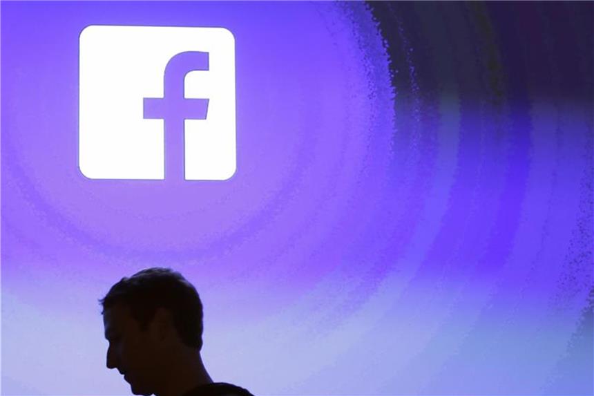Facebook setzt auf Online-Dating Mark Zuckerberg, Gründer von Facebook, geht am Firmensitz an einem leuchtenden Facebook-Logo vorbei. Foto: Marcio Jose Sanchez, AP