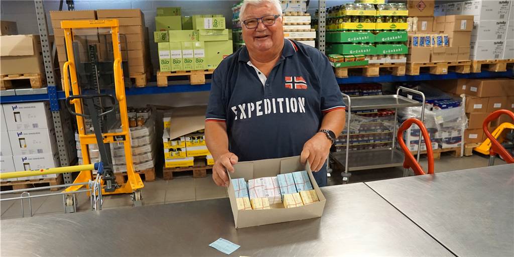 Zu großer Andrang: Einkauf für Kunden der Tafel bald nur noch 14-tägig möglich Ein Mann hält eine Box mit Karten