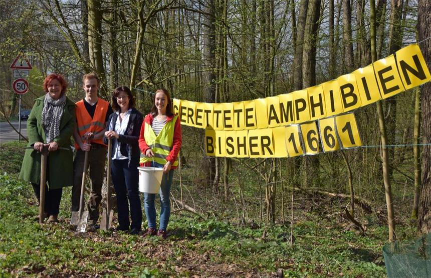 So wird Kröten in Cappenberg das Leben gerettet Martina Schmidt von Boeselager (v.l./Leiterin Waldschule), Lukas Neumann, Jutta Röttger (Stadt Selm) und Katharina Felderhoff vor dem Banner Im Dreischfeld.