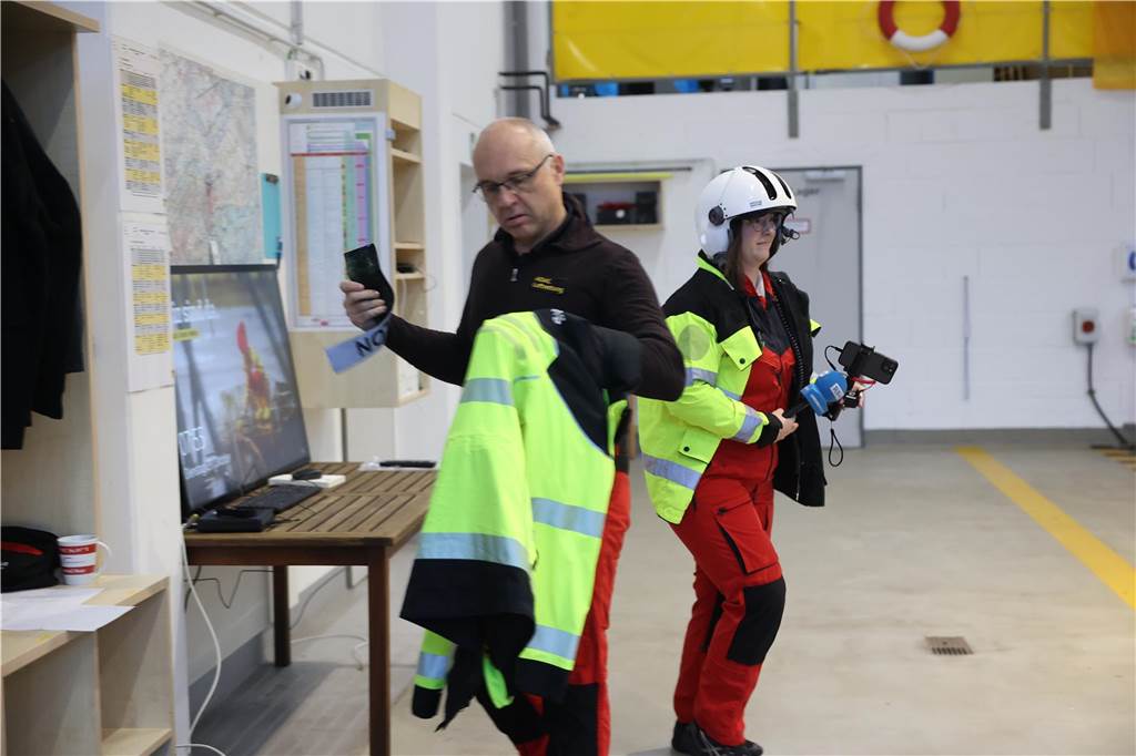 Zwei Menschen mit ADAC-Kleidung in einer Halle.