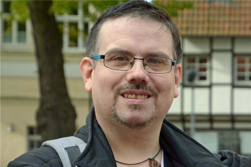 Jack Tengo aus Werne spielt jetzt den schusseligen „Heiner“ Ein Mann mit Bart steht vor einem Haus.
