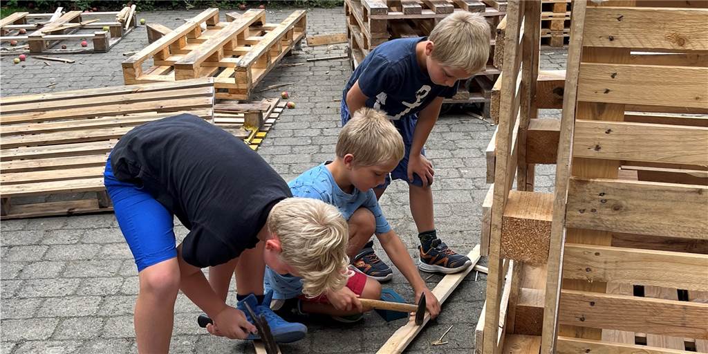 Matthis, Len und Liam arbeiten im Nordkirchener Ferienprogramm eifrig auf dem Bauspielplatz.