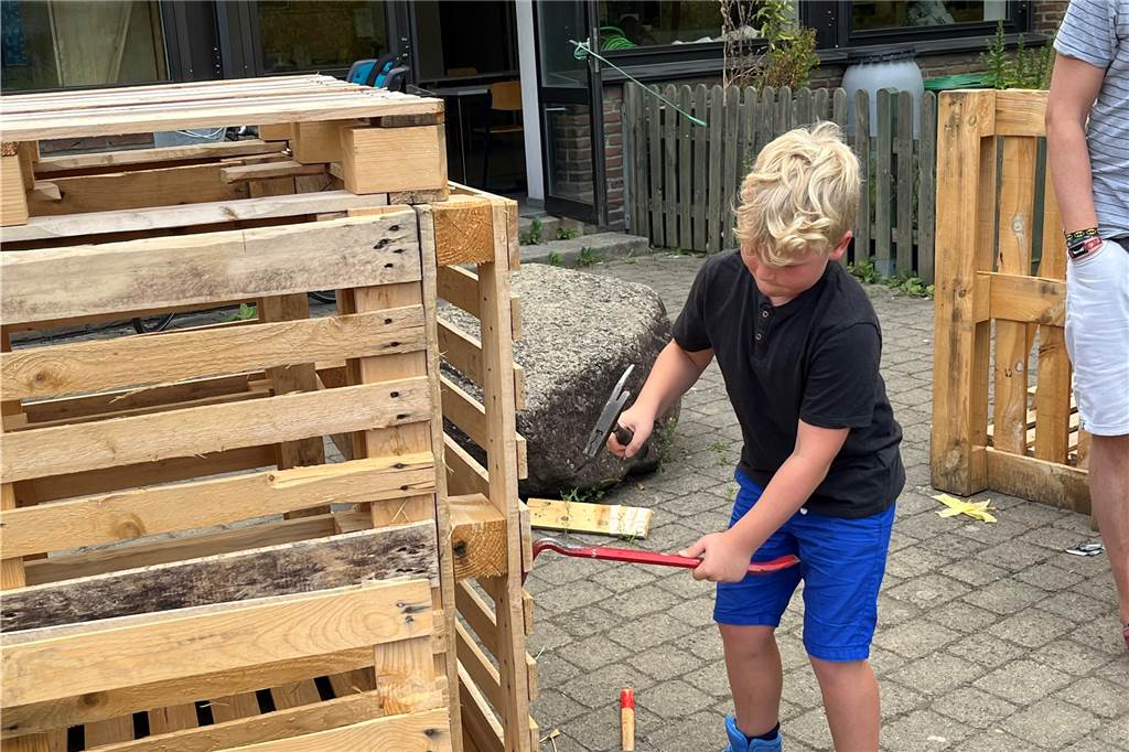 Matthis schlägt mit dem Hammer Nägel in das Holz.