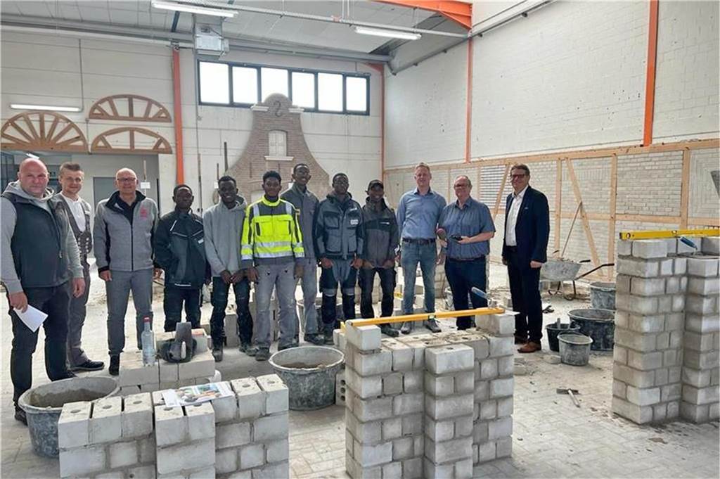 Junge Leute aus Afrika ausbilden: Fachkräfte-Modell mit Mosambikern lässt hoffen Die sechs Praktikanten vor einer gemauerten Mauer in der Berufsbildungsstätte