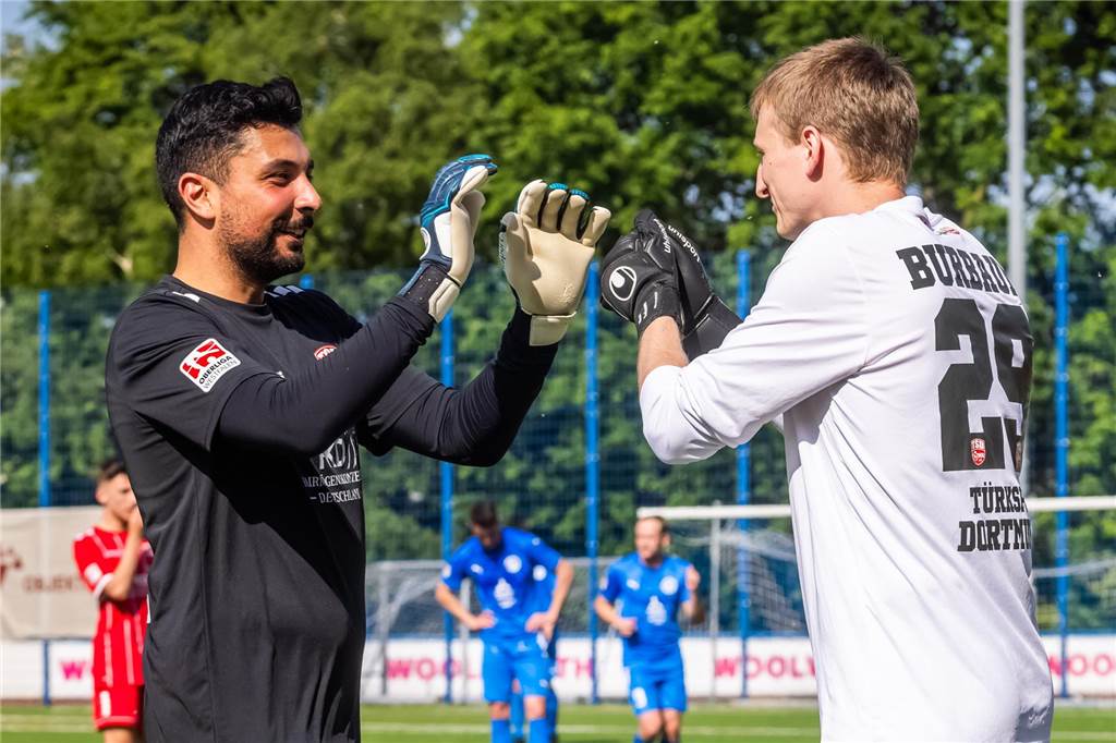 Schüren verpflichtet Torwart von Türkspor Max Burbaum und Mo Acil klatschen sich ab.