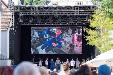 Mehrere hundert Menschen verfolgen auf einer Leinwand vor dem Alten Rathaus in Künzelsau den Live-Call mit Alexander „Astro-Alex“ Gerst. Foto: Sebastian Gollnow