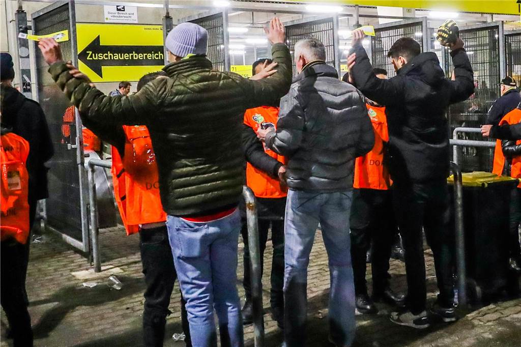 So einfach ist es, Bengalos in den Signal-Iduna-Park zu schmuggeln Mein Freund (links) und ich (2 v.r.) bei den Einlasskontrollen. In der rechten Hand, halte ich die Attrappe eingewickelt in meinem Schal.