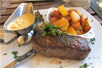 Meine Hauptspeise: 250 Gramm Rumpsteak vom argentinischen Rind. Dazu eine Sauce Bearnaise sowie Röstkartoffeln und Bohnen im Speckmantel.
