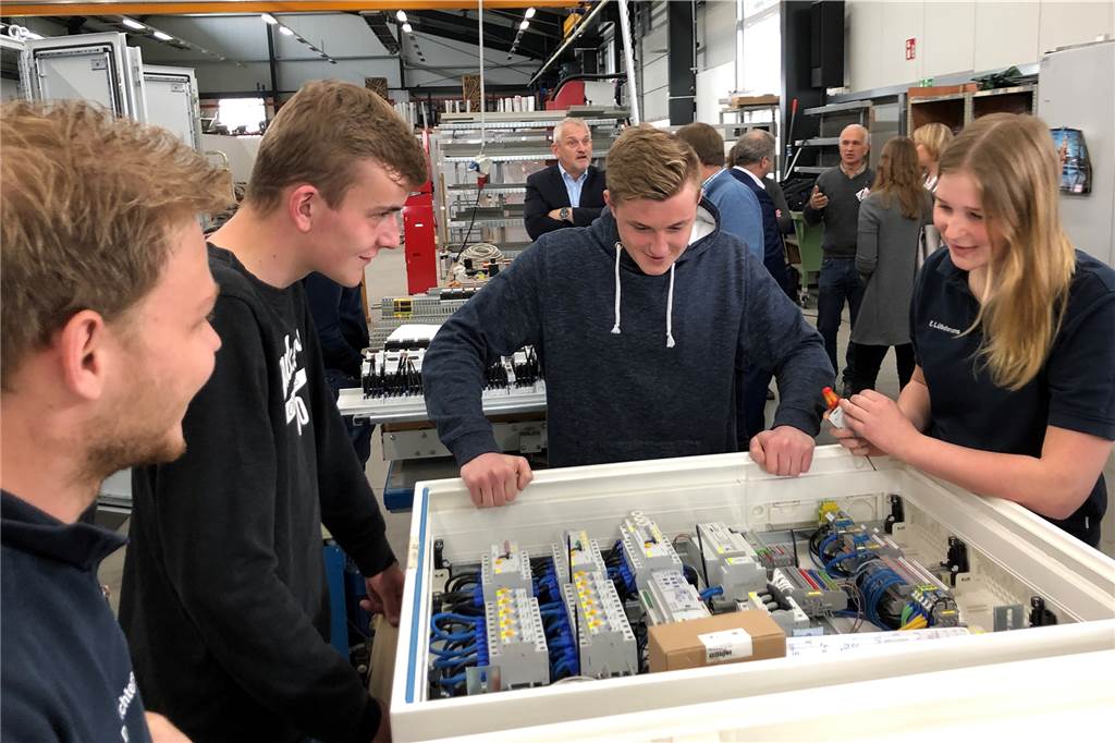 Pilotprojekt weist Losbergschülern Wege in die Arbeitswelt Meister, Azubis und Losbergschüler im Fachgespräch über die technischen Details eines Schaltschranks.