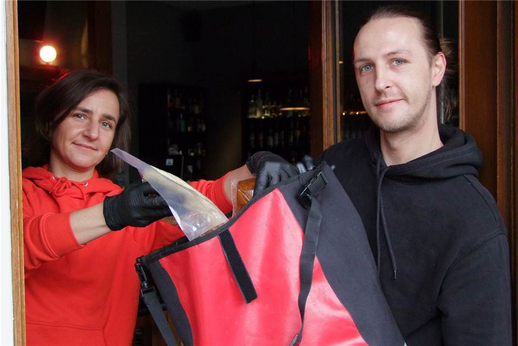 Fensterverkauf von Dortmunder Restaurants kommt gut an - und wird größer Melanie Adam und Marc Hyggenberg packen portioniertes Essen in einen Rucksack.