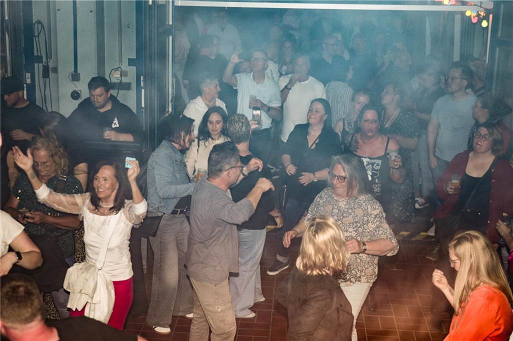 Menschen feiern den Tanz in den Mai bei der Feuerwehr in Dortmund-Bodelschwingh mit Musik, Essen und guter Stimmung.