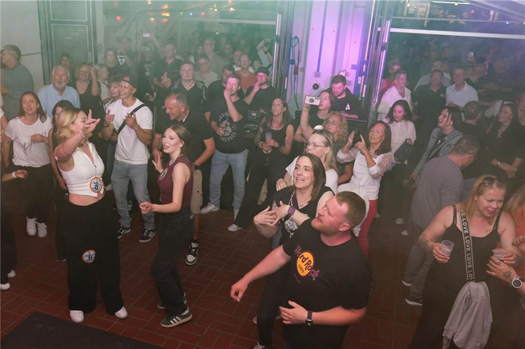 Menschen feiern den Tanz in den Mai bei der Feuerwehr in Dortmund-Bodelschwingh mit Musik, Essen und guter Stimmung.