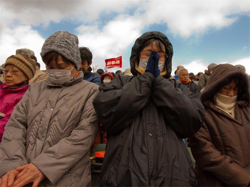Japan und die Welt gedenken der Tsunami- und Atomtod-Opfer Menschen in Japan gedenken mit einer Schweigeminute der Opfer der Erdbeben-, Tsunami- und Atomkatastrophe vor einem Jahr. Foto: Christopher Jue
