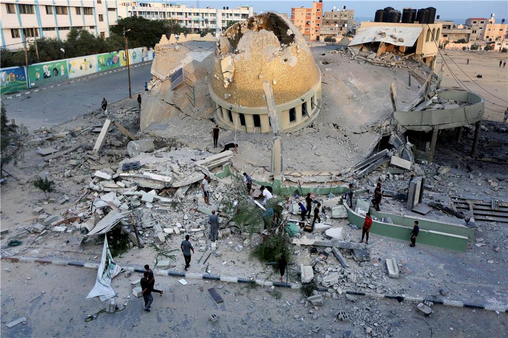 Israel: Massive Raketenangriffe aus Gazastreifen : Hamas startet „Militäroperation“ gegen Israel Menschen stehen vor einer Moschee, die bei einem israelischen Luftangriff in Khan Younis im Gazastreifen zerstört wurde.