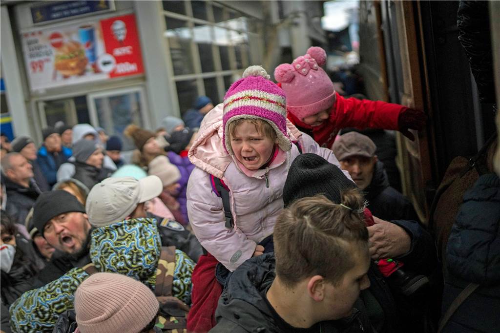 Psychologin über Kriegs-Traumata: „Darüber sollten sich auch Gastfamilien im Klaren sein“ Menschen tragen ihre Kinder und versuchen am Bahnhof von Kiew in einen Zug nach Lwiw zu steigen.