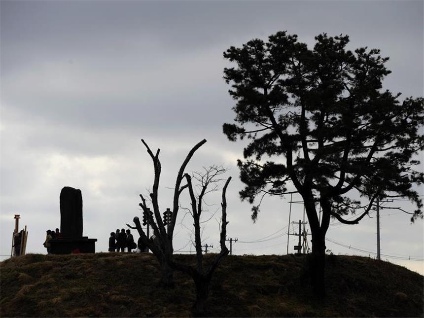 Japan und die Welt gedenken der Tsunami- und Atomtod-Opfer Menschen versammeln sich an einem Gedenkstein für die Opfer der Katastrophe. Foto: Franck Robichon