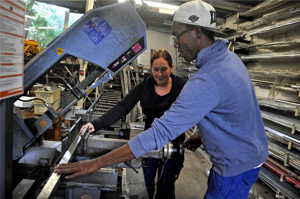 Ein Mitarbeiter der Firma Bereszynski montiert Metallteile.