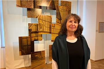 Künstlerin Mia Weinberg steht vor einer Installation, die das Haus ihrer Urgroßmutter zeigt.