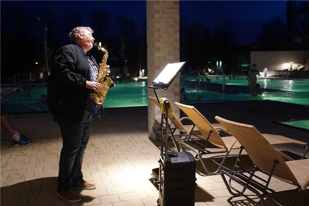 Besucher entspannen bei „Music in the Sole“ im Solebad Michael Gick steht mit seinem Saxofon am Beckenrand und spielt.