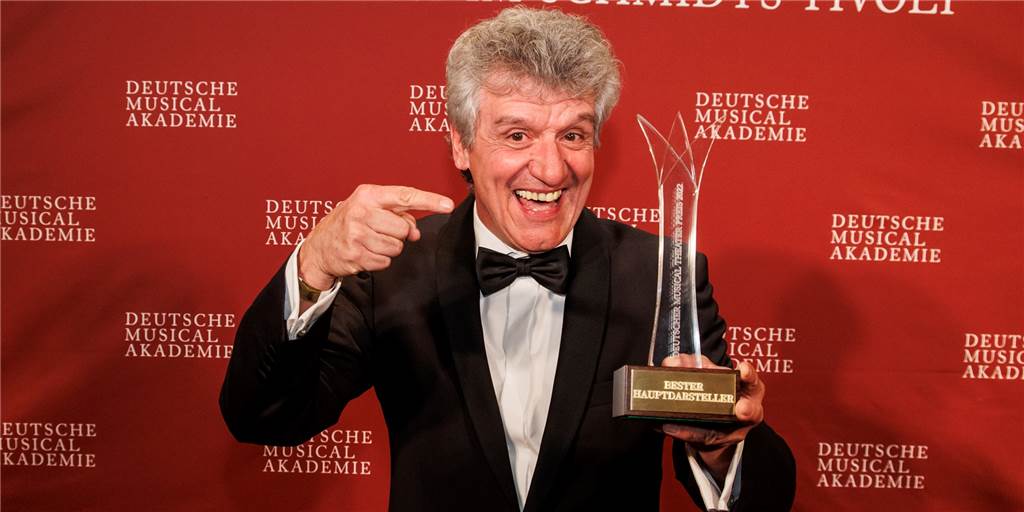 Deutscher Musical-Preis: Gewinner steht in Castrop-Rauxel auf der Bühne Michael Ophelders zeigt seine Auszeichnung.