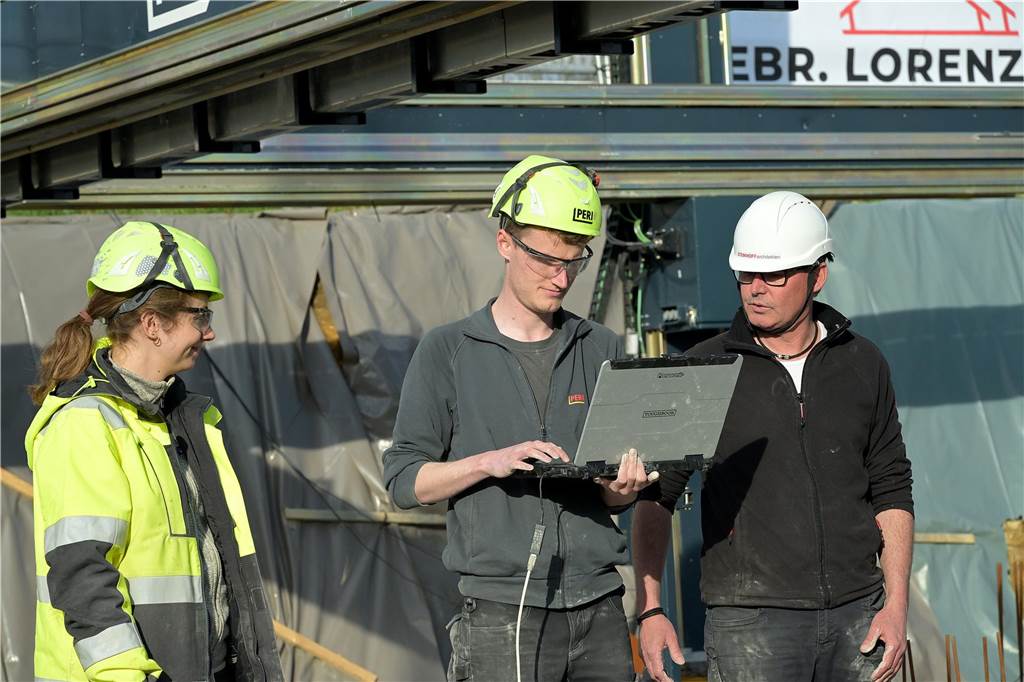 Michael Oßwald (Firma Peri) und Architekt Lothar Steinhoff schauen sich auf dem Laptop an, wie es mit dem 3D-Druck weitergeht.