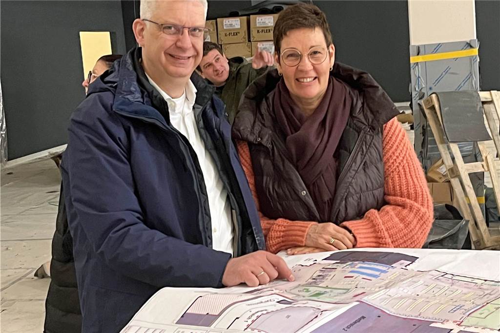 Michael und Nicole Krummenerl begutachten die Pläne fü die Einrichtung des neuen Rewe Marktes.