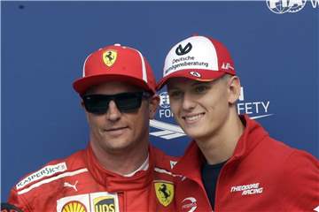 Mick Schumacher (r) posiert auf der Rennstrecke von Monza nach dem Qualifying mit Ferrari-Pilot Kimi Räikkönen. Foto: Luca Bruno/AP