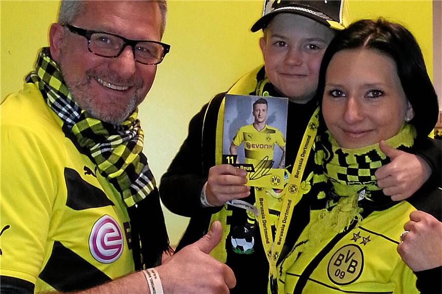 Hand in Hand mit Marco Reus Milo mit Thorsten Stächelin, seiner Mutter und der Autogrammkarte von Marco Reus.