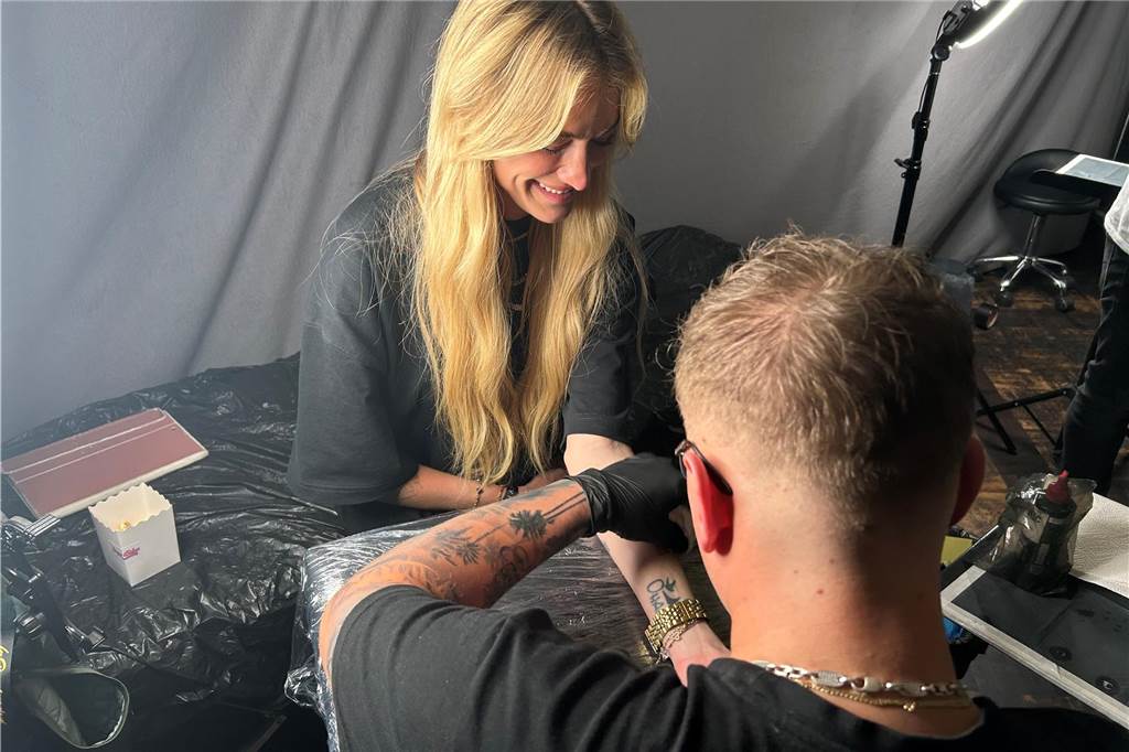 Reality-TV Stars feiern in Dortmunder Club Mimi Gwozdz, während sie tätowiert wird.